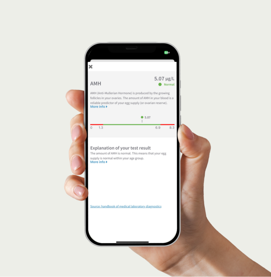 Hand holding a smartphone displaying a medical app with test result information.