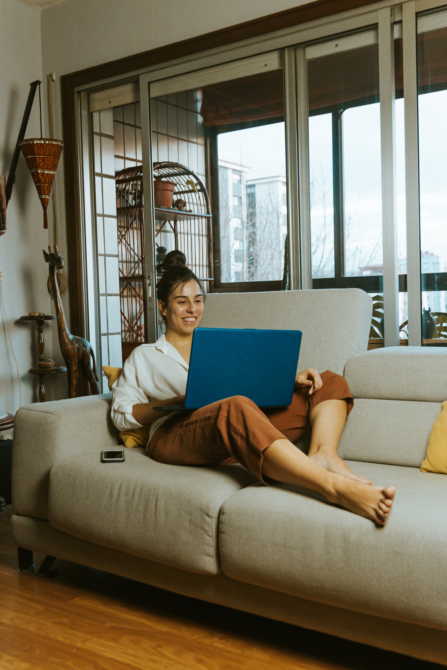 Person sitting on a couch, looking at a report on her laptop